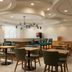Hampton Inn by Hilton Hopewell Fort Lee breakfast area with tables, chairs, and a modern ceiling design