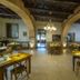 Palazzo Del Papa Agriturismo in Spoleto dining room with stone arches, chandeliers, and wooden tables