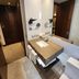 Hotel Los Españoles Plus Santiago bathroom with sink, mirror, towels, and wood-paneled doorway