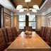 Westhouse Hotel New York meeting room with long wooden table, tufted chairs, and large city-view windows
