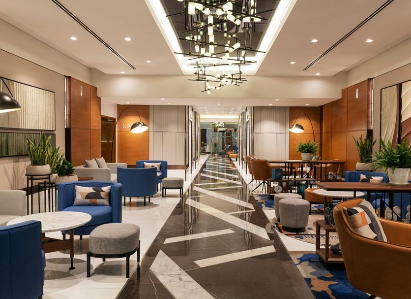 Sheraton The Walk, Dubai lobby with blue seating, patterned floor, and modern chandelier lighting