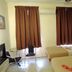 Hotel Seri Nilai room in Kampung Baharu Nilai with two twin beds, desk, TV and curtained windows
