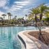 Legacy Vacation Resorts - Palm Coast pool with palm trees and resort buildings