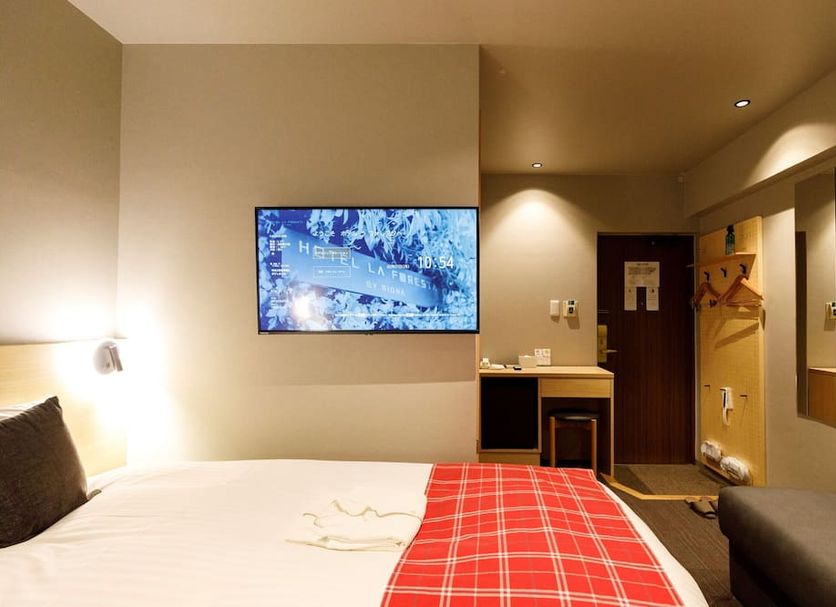 HOTEL LA FORESTA BY RIGNA room in Fukuoka with bed, wall-mounted TV, desk and chair