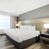 Country Inn & Suites by Radisson, Merrillville, IN guest room with king bed, window, and bedside lamps