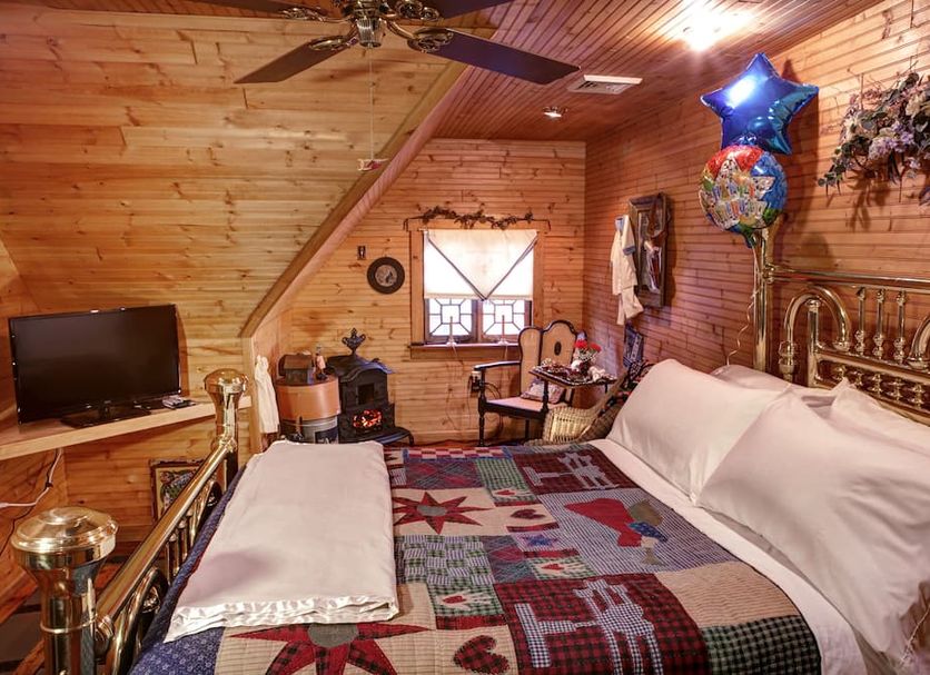 The Queen, A Victorian Bed & Breakfast in Bellefonte: cozy attic guest room with brass bed and patchwork quilt