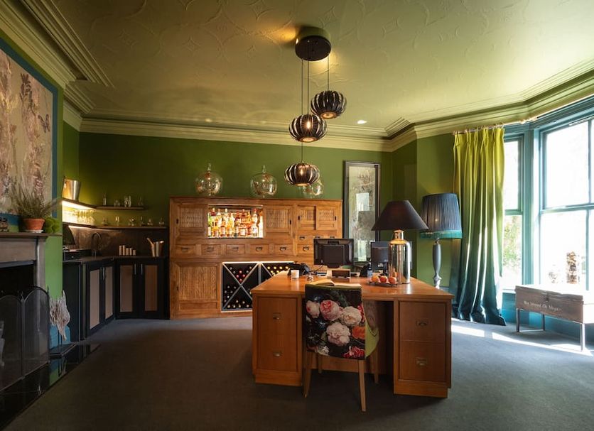 Eleven Didsbury Park Hotel in Manchester lounge with green walls, fireplace, desk and large bay window