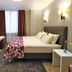 City Park Hotel in Chisinau guest room with king bed, wall-mounted TV, desk and window with curtains