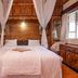 Hotel Troy Nairobi bedroom with four-poster bed, wood-paneled walls and sheer curtains