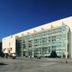 Paraiso Hostel in Barcelona exterior with modern glass facade beside a large white building