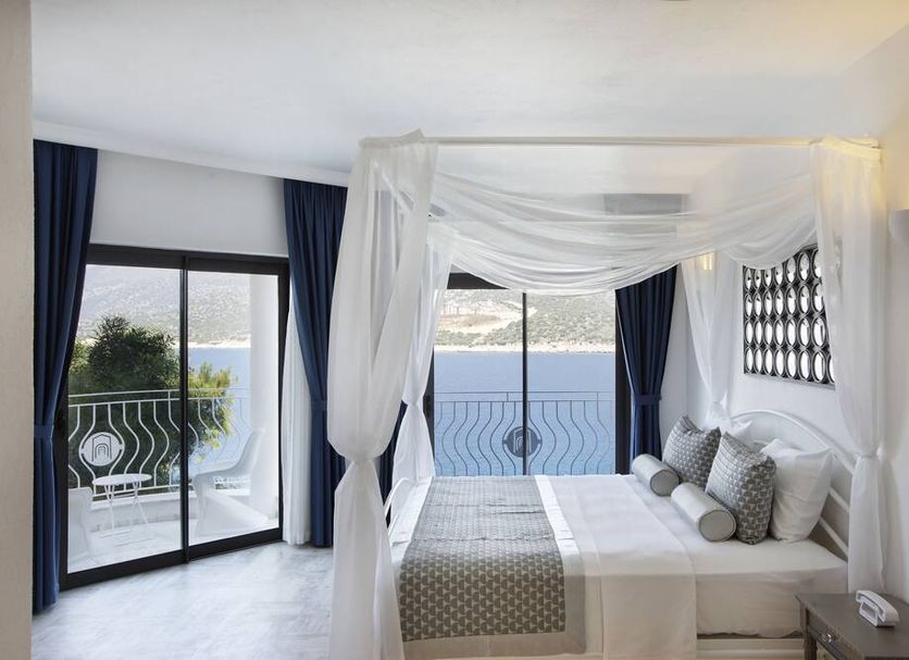 Alley Prime Hotel in Kaş bedroom with four-poster bed and sea-view balcony