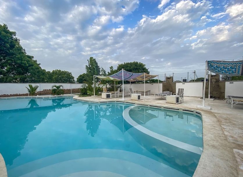 Aqua Resort in Diani Beach with a curved outdoor swimming pool and shaded seating area