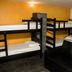 Global Hostel Sao Paulo bunk room with multiple bunk beds and a black sofa in Sao Paulo