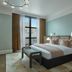 Citizen House in Oklahoma City guest room with king bed, bench, and city view through tall window