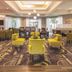 La Quinta Inn & Suites by Wyndham Fort Worth City View lobby seating area with yellow chairs and patterned carpet