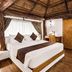 Vijayshree Resort, Hampi in Hosapete: thatched-roof bedroom with king bed and wooden furnishings