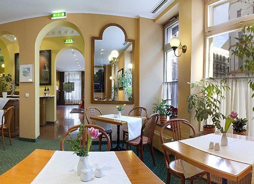 Galerie Hotel Leipziger Hof in Leipzig dining room with arched mirrors, tables, and potted plants