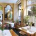 Galerie Hotel Leipziger Hof in Leipzig dining room with arched mirrors, tables, and potted plants