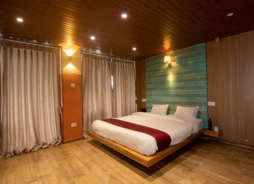 Everest Manla Resort in Nagarkot guest room with floating bed, wood ceiling and curtains