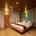 Everest Manla Resort in Nagarkot guest room with floating bed, wood ceiling and curtains