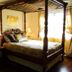 Gatekeeper's Retreat in Niagara-on-the-Lake: four-poster bed in a bright guest room with floral chair and lamp