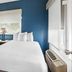 SureStay by Best Western Santa Monica guest room with bed, blue accent wall, window, and wardrobe