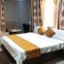 Golden Key Hotel Accra guest room with king bed, lounge chair, TV, and window curtains