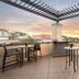 Hyatt Centric The Woodlands rooftop terrace with tables, chairs and sunset views