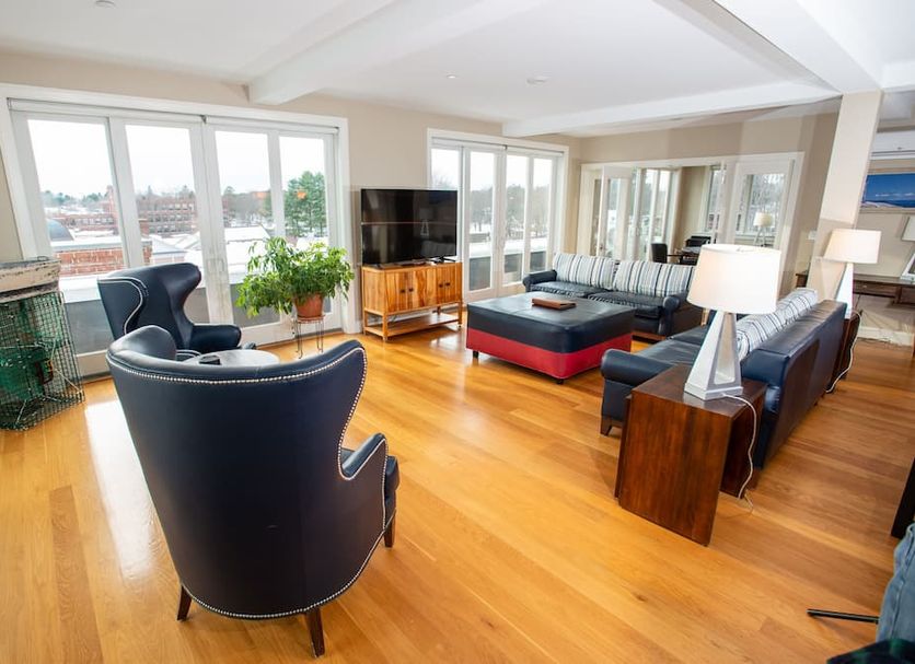 84 Main in Kennebunk: bright hotel lounge with hardwood floors, seating area, TV, and windows with water view