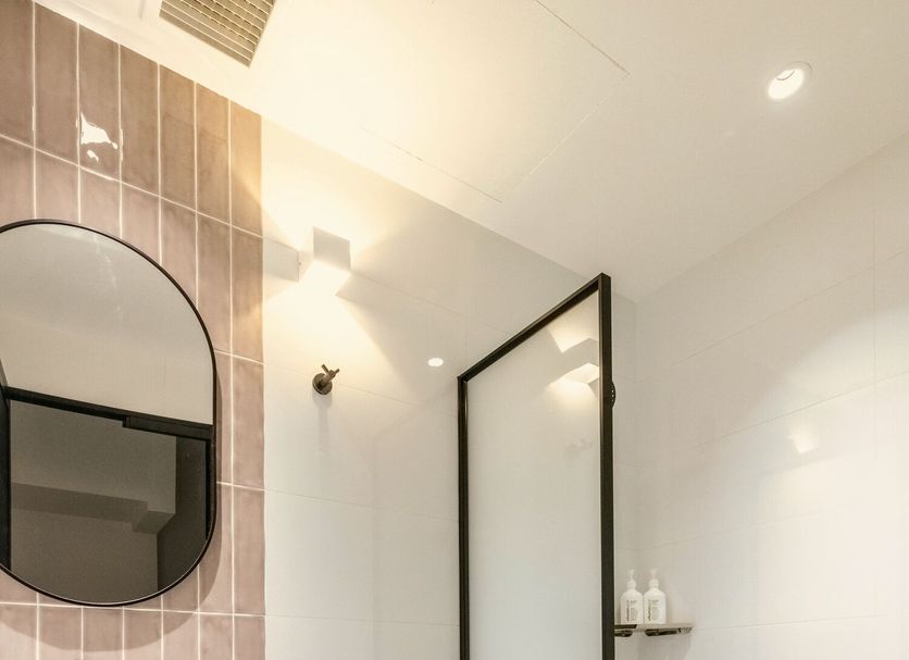 Bathroom at Habyt Studios Kallang in Singapore with shower, toilet, sink and pebble-style floor