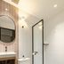 Bathroom at Habyt Studios Kallang in Singapore with shower, toilet, sink and pebble-style floor