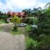 Sunny Point Hotel in Davao City with a landscaped driveway, palm trees, and parked vehicle
