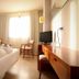 Hotel Balneario Valle del Jerte room in Valdastillas with bed, TV, desk and bright window