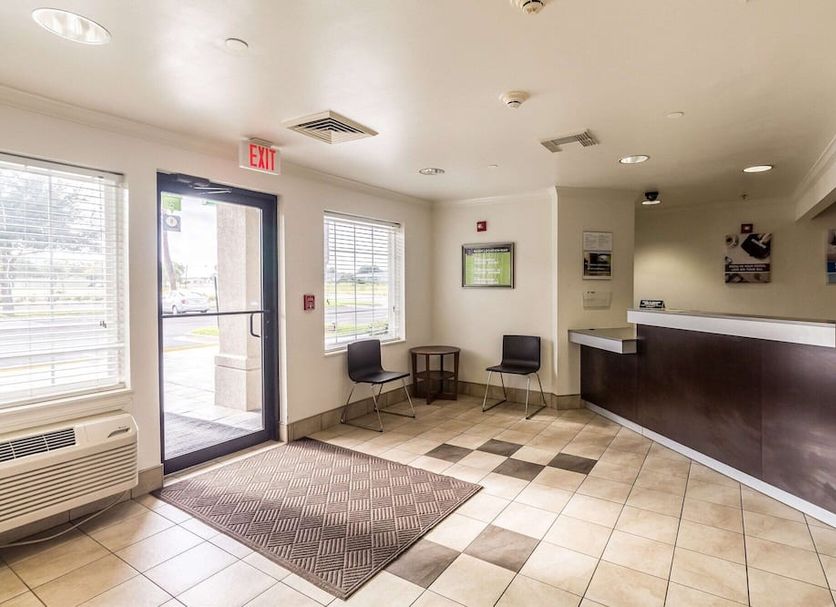 Studio 6 Mcallen Tx lobby with front desk, seating area and glass entrance in McAllen