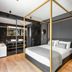 Colors Hotel Athens in Athens: modern room with gold canopy bed, black walls, and freestanding tub