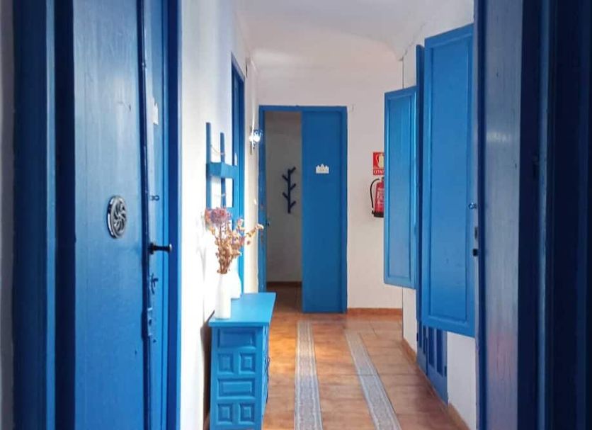 The Dreamers&Co Córdoba hallway with bright blue doors, cabinets and a long runner rug