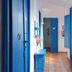 The Dreamers&Co Córdoba hallway with bright blue doors, cabinets and a long runner rug