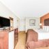 Baymont by Wyndham Midland Airport guest room with king bed, TV, and bedside lamps in Midland