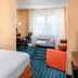 Fairfield Inn & Suites by Marriott Chicago Tinley Park room with bed, desk, sofa, and window seating