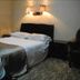 Orange Crystal Hotel Xuzhou Suning Plaza guest room with bed, wall lamps and armchair in Xuzhou