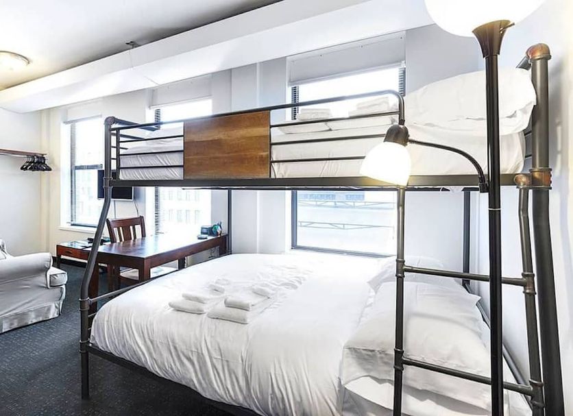 Temple Place Suites Boston room with bunk bed, queen bed, desk and large windows