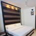 Ritumbhara Resorts Alwar bedroom with king bed, ceiling fan, seating area and wall-mounted TV