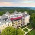 1886 Crescent Hotel and Spa in Eureka Springs overlooking forested hills at sunset