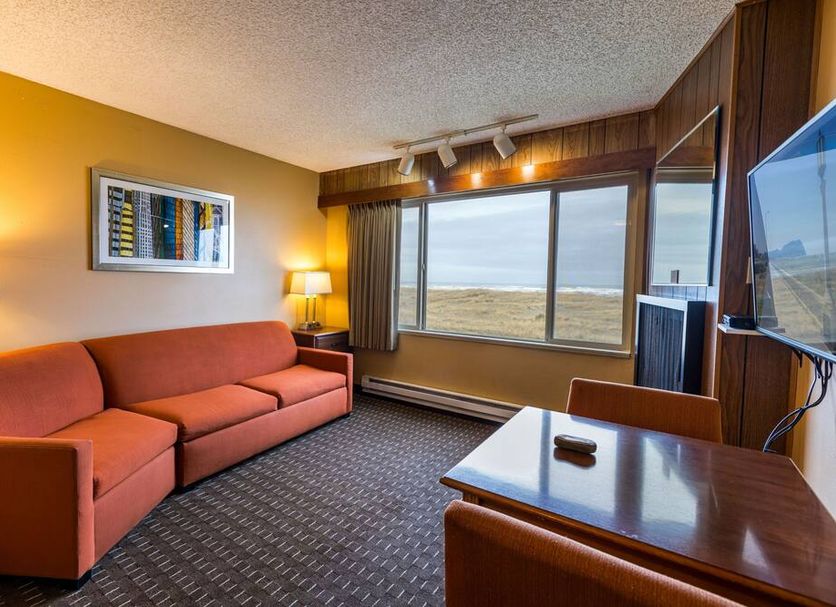 Ebb Tide Oceanfront Inn in Seaside room with sofa, TV, and ocean-view window