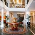 The Sebel Quay West Auckland lobby with staircase, mezzanine balcony and circular table