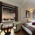 Residenza Delle Arti Rome guest room with king bed, small table and chairs, and street view window