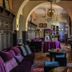 Hotel Boutique Castillo Rojo in Santiago lounge with purple sofas, arches, chandeliers and bar seating