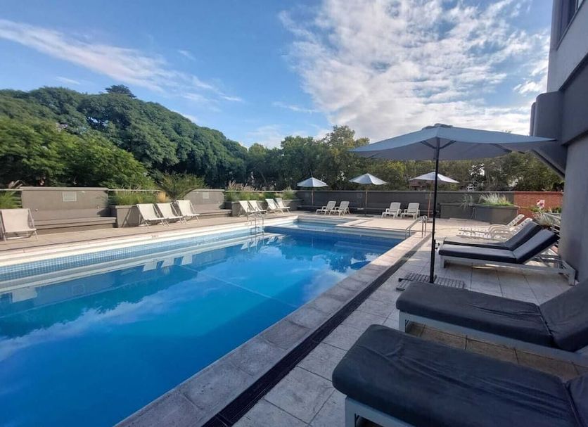 Hotel Raices Aconcagua in Mendoza features an outdoor pool with loungers and mountain views