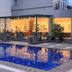 Horison Hotel Sukabumi poolside patio with lit outdoor swimming pool and lounge seating in Sukabumi
