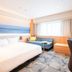 Richmond Hotel Miyazaki Ekimae guest room with bed, sofa, desk and large window in Miyazaki